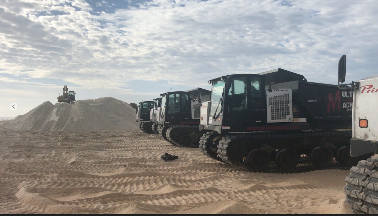 concrete frontloaders lined up along Palm Coast beach after a hurricane