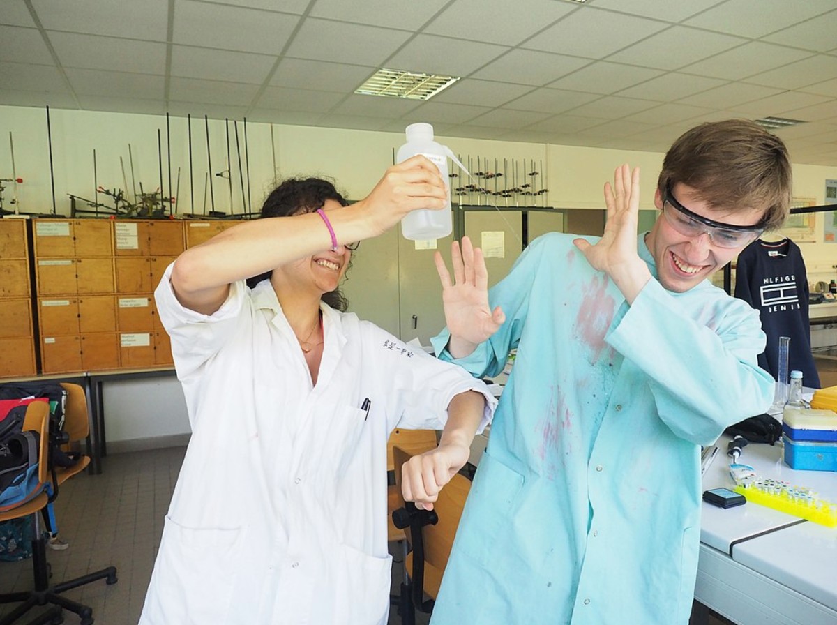 In this pic a female scientist pours a chemical solution on a colleague - conflict resolution